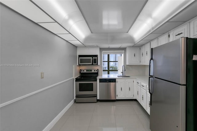 kitchen featuring stainless steel appliances, a sink, light countertops, and white cabinetry