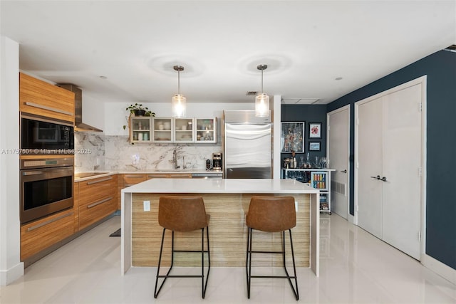 kitchen with black appliances, modern cabinets, light countertops, and wall chimney range hood