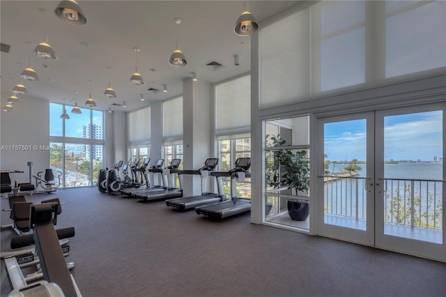 exercise room featuring a water view and visible vents