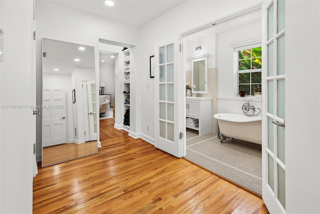 interior space featuring vanity, a freestanding tub, hardwood / wood-style flooring, and recessed lighting