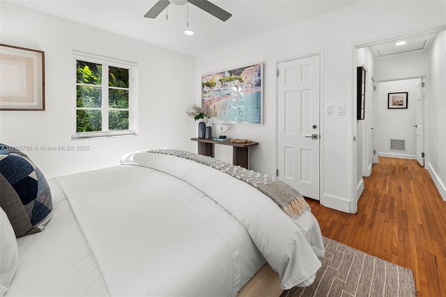 bedroom with attic access, recessed lighting, visible vents, and wood finished floors