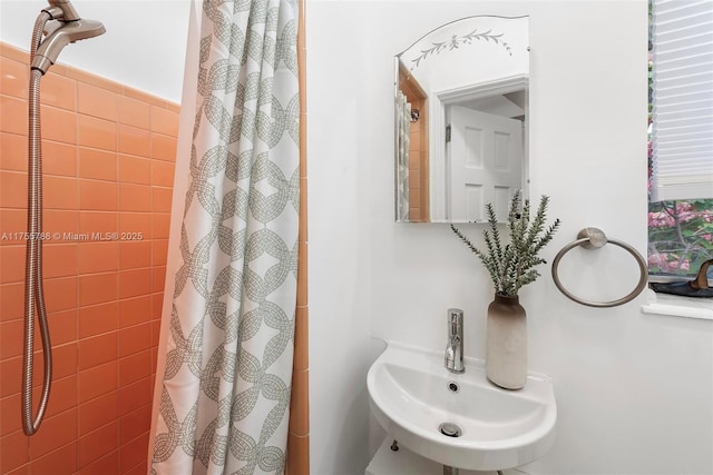 full bath with curtained shower and a sink