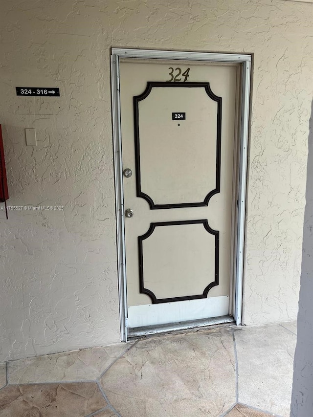 property entrance with stucco siding