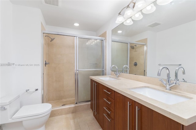 bathroom with toilet, a shower stall, and a sink