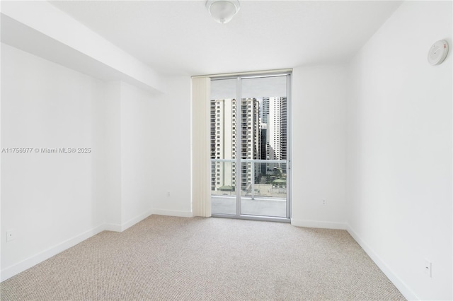 unfurnished room featuring floor to ceiling windows, carpet, and baseboards