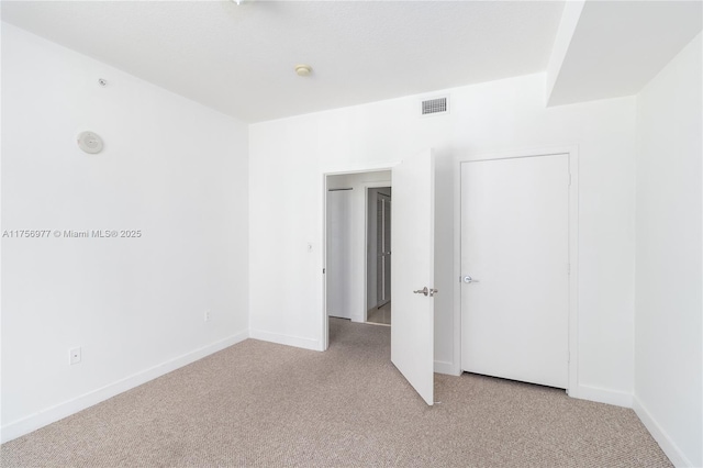 unfurnished bedroom featuring carpet, visible vents, and baseboards