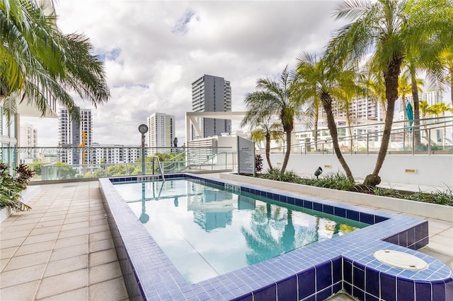 view of pool featuring fence and a city view