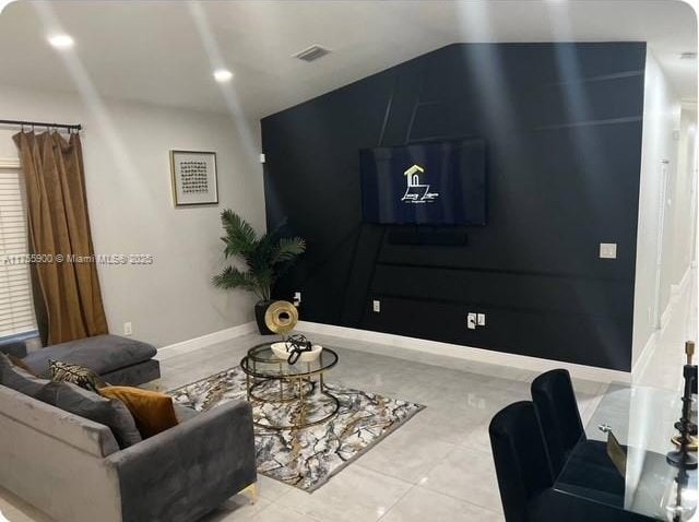 tiled living area featuring recessed lighting, vaulted ceiling, and baseboards