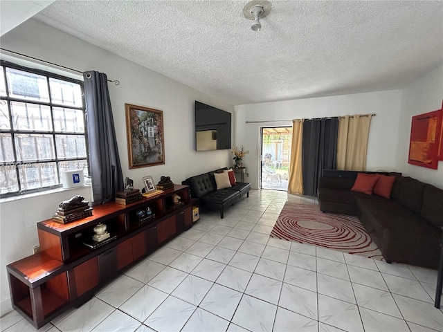 living room with a textured ceiling and light tile patterned floors