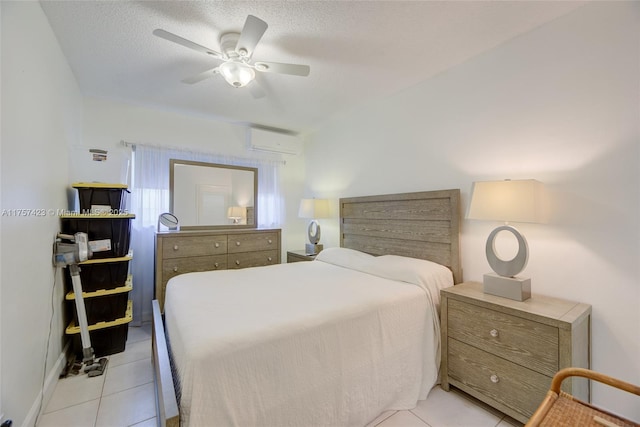 bedroom featuring light tile patterned floors, a textured ceiling, a ceiling fan, and an AC wall unit