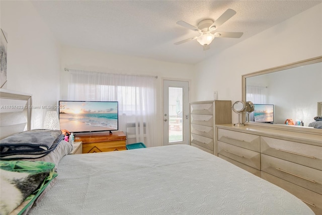 bedroom featuring lofted ceiling, ceiling fan, and a textured ceiling