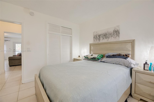 800 SW 11th Ave Unit 9A, Hallandale Beach, FL 33009 - bedroom featuring an AC wall unit, light tile patterned floors, baseboards, and a closet