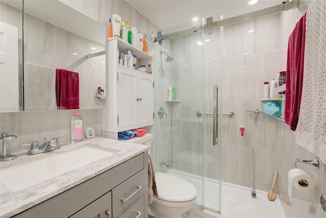 bathroom with a stall shower, vanity, and toilet