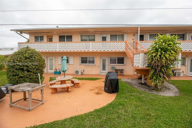 back of property featuring a yard, ac unit, a patio, and stucco siding