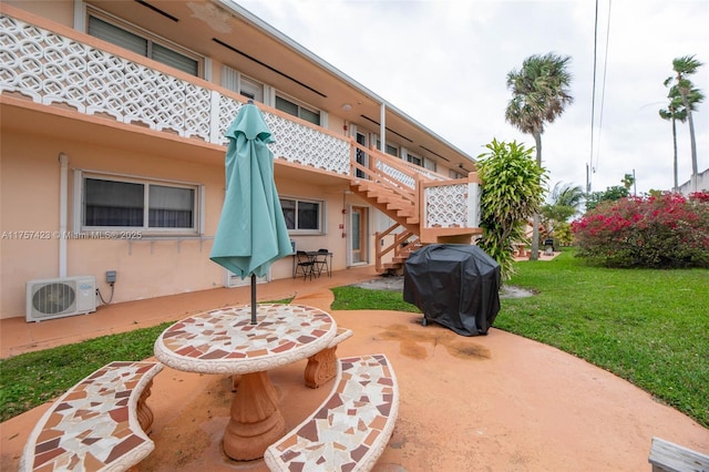 view of patio / terrace featuring ac unit, a grill, and stairway