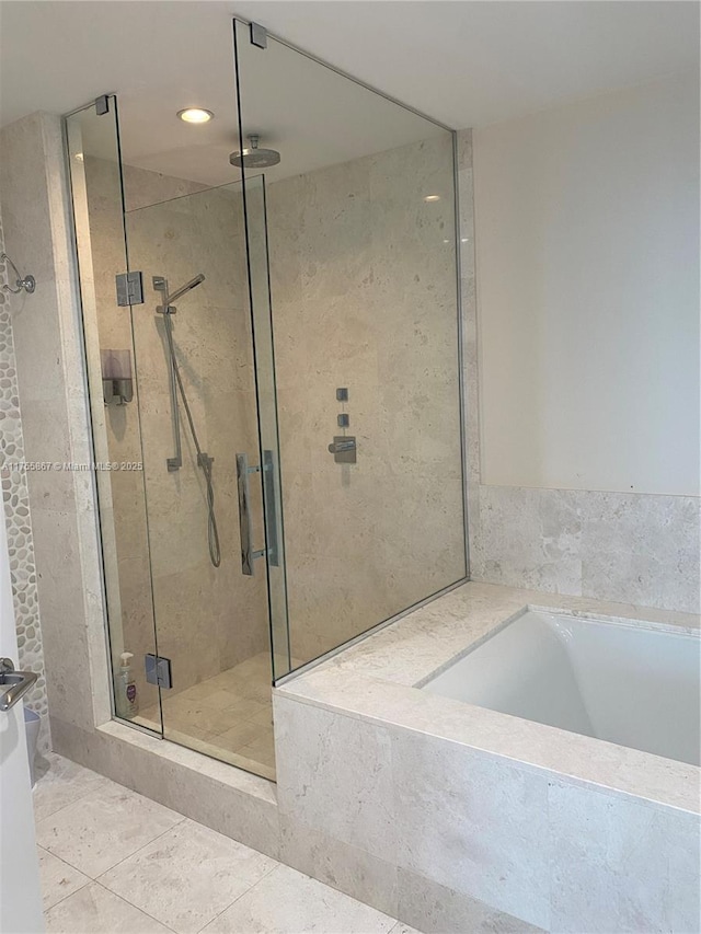 full bathroom featuring a stall shower, a garden tub, and tile patterned floors