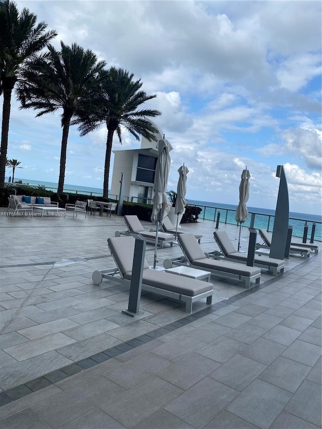 view of community with a patio area and a water view