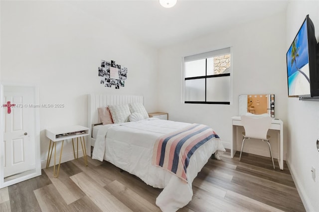 bedroom featuring baseboards and wood finished floors