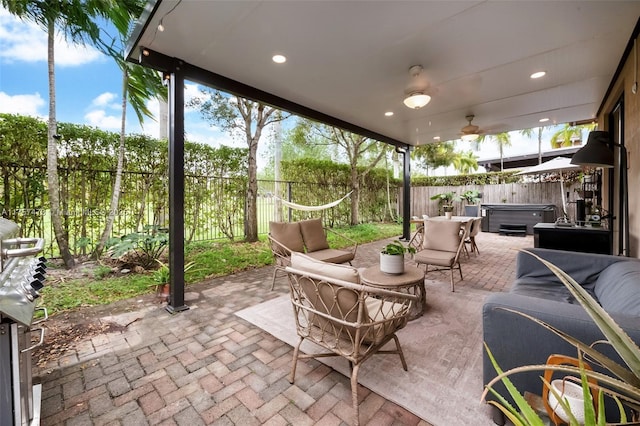 view of patio / terrace with ceiling fan, a fenced backyard, an outdoor living space, and a hot tub