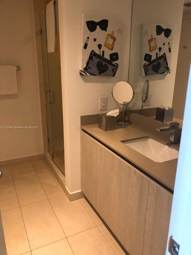 full bath featuring baseboards, a stall shower, vanity, and tile patterned floors