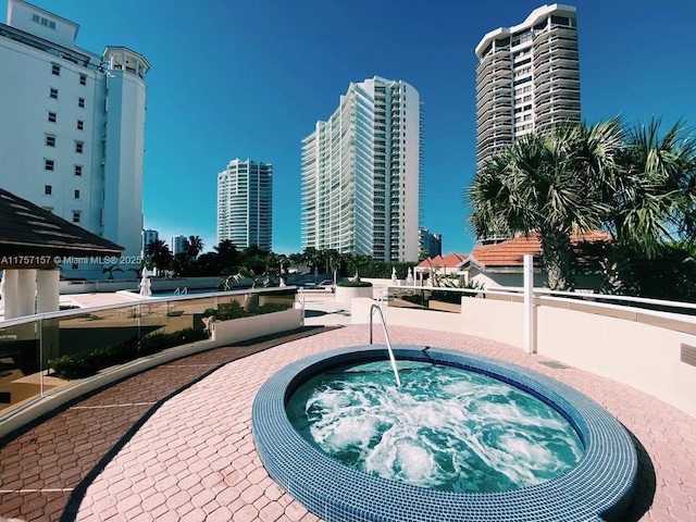 view of pool featuring a view of city and a community hot tub