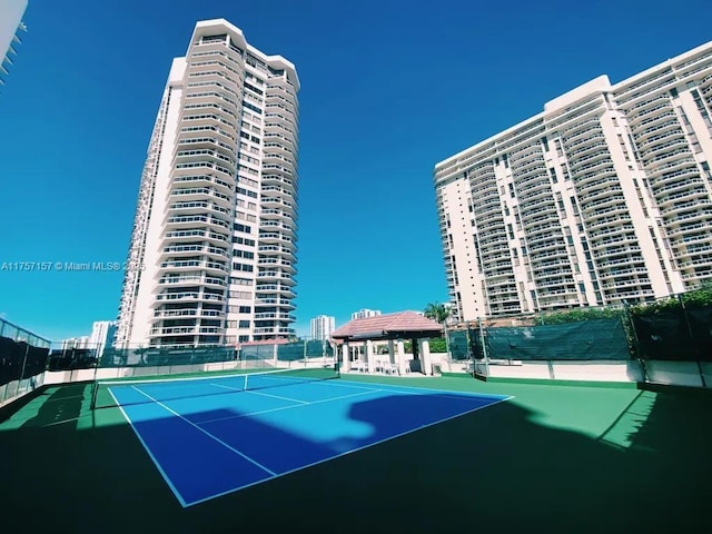 view of tennis court featuring a gazebo and fence