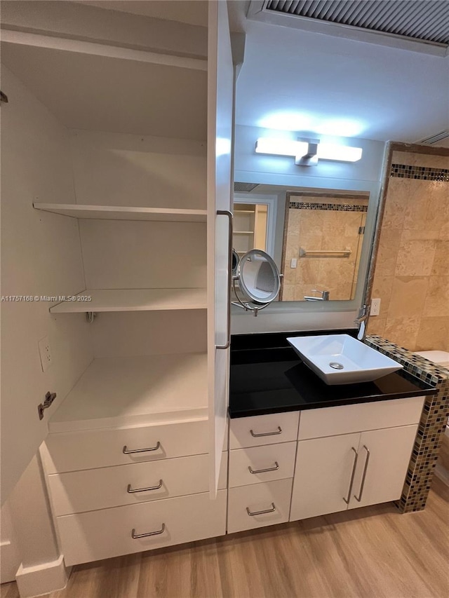 bathroom with visible vents, wood finished floors, and vanity