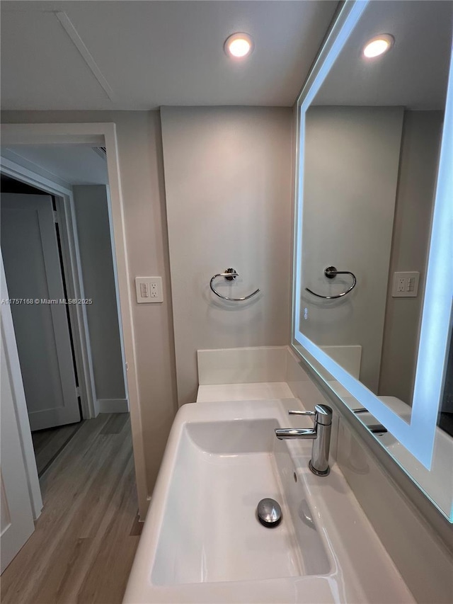 bathroom featuring recessed lighting, vanity, and wood finished floors