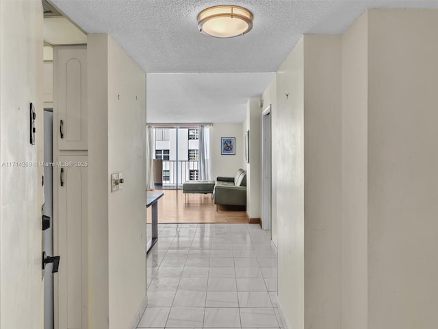 hall featuring baseboards and a textured ceiling