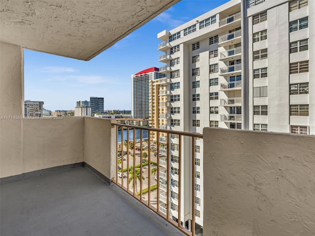 balcony featuring a water view and a city view