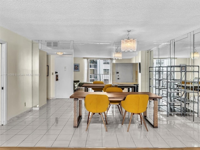 dining space with light tile patterned floors, visible vents, and a textured ceiling