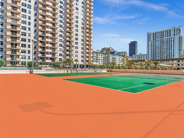 view of sport court featuring fence and a city view