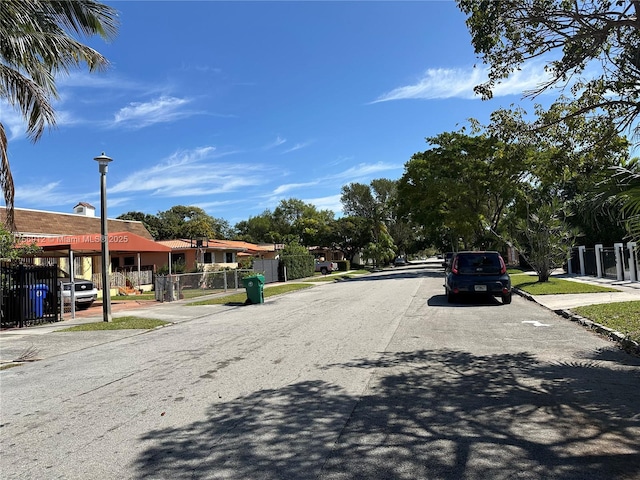 view of road featuring sidewalks, street lights, and curbs