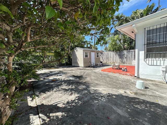 exterior space with an outbuilding, fence, and a shed