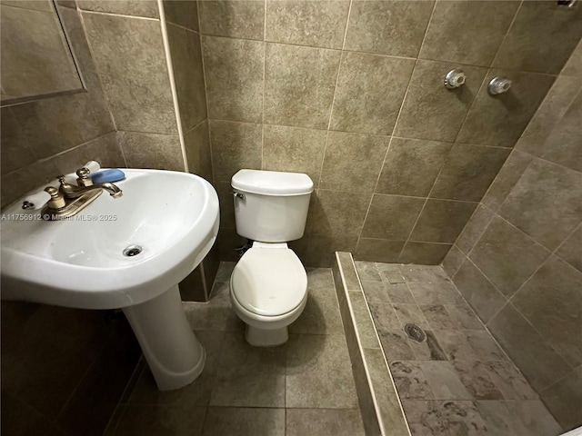 bathroom featuring tile patterned flooring, a shower stall, and toilet