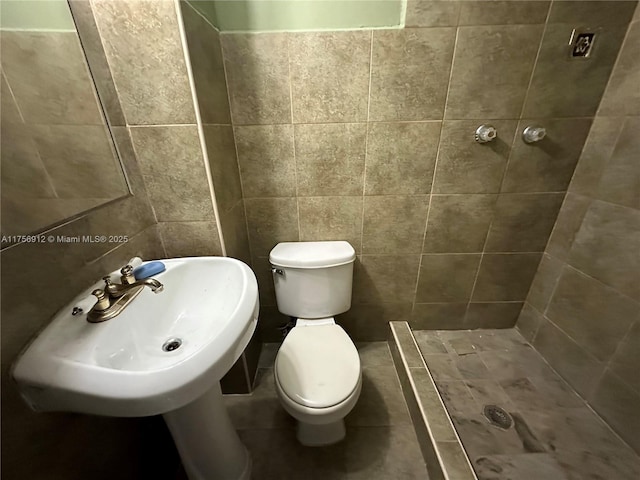 full bath with a stall shower, tile walls, and toilet