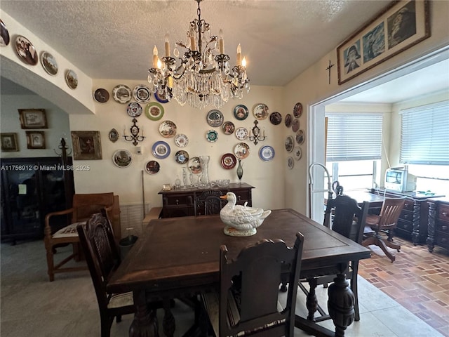 dining area featuring a textured ceiling and a chandelier