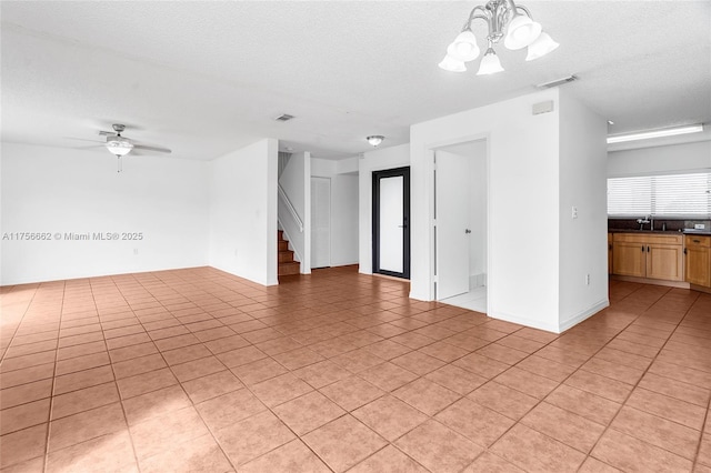 unfurnished room featuring visible vents, a sink, a textured ceiling, and stairs