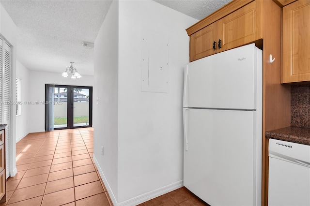 kitchen with white appliances, a textured ceiling, french doors, and light tile patterned floors