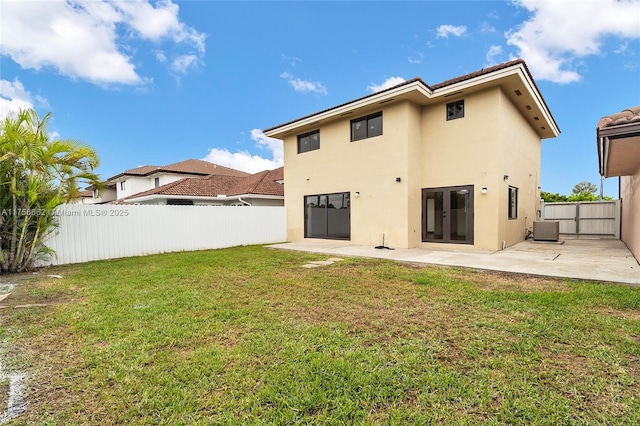 rear view of house featuring cooling unit, a patio area, a lawn, and a fenced backyard