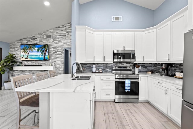 1222 Stardust Way, Royal Palm Beach, FL 33411 - kitchen featuring appliances with stainless steel finishes, high vaulted ceiling, decorative backsplash, and a sink