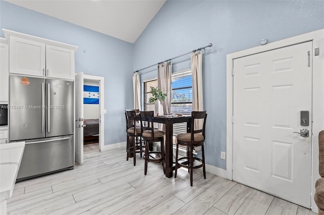 1222 Stardust Way, Royal Palm Beach, FL 33411 - dining area featuring light wood finished floors, baseboards, and high vaulted ceiling