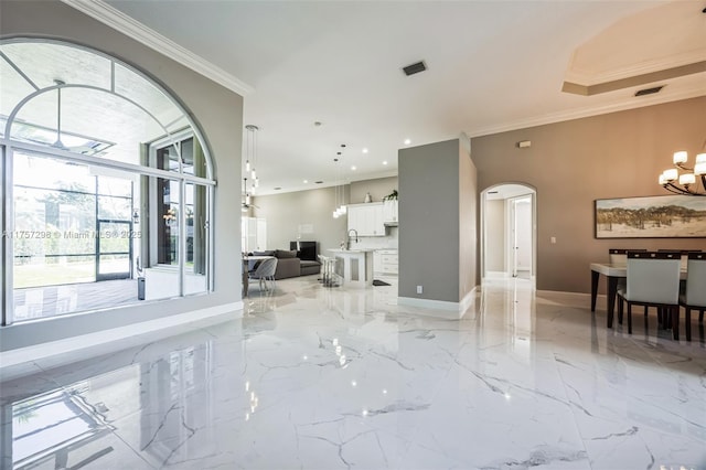 spare room with arched walkways, crown molding, visible vents, an inviting chandelier, and baseboards