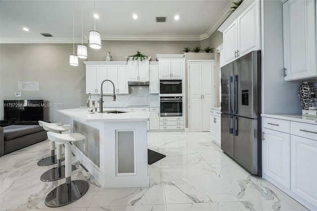 kitchen with appliances with stainless steel finishes, marble finish floor, visible vents, and a sink