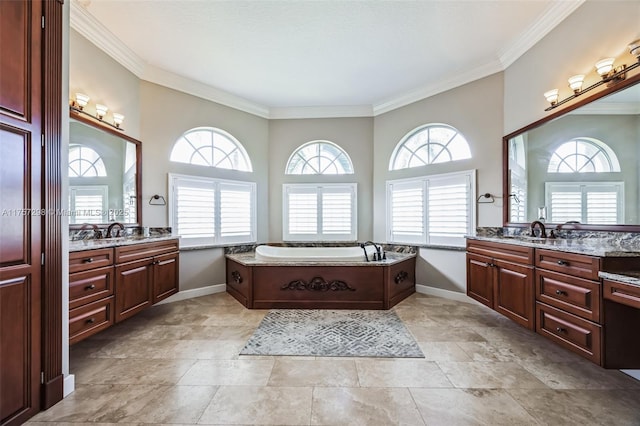 full bathroom featuring two vanities, a garden tub, and baseboards