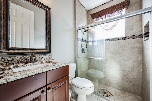 bathroom featuring toilet, a shower stall, and vanity