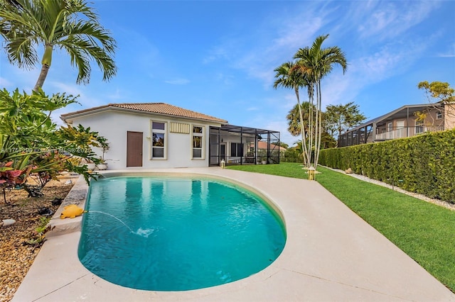 view of pool with glass enclosure, a patio area, a fenced in pool, and a yard