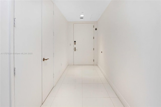 hall featuring light tile patterned floors, visible vents, baseboards, and recessed lighting