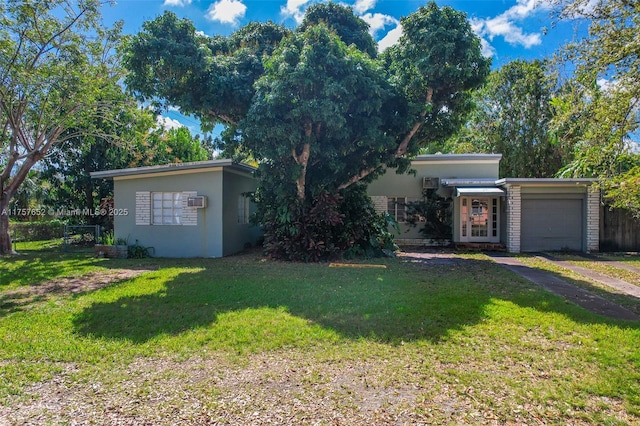 view of front of home with a garage, fence, a front lawn, and stucco siding