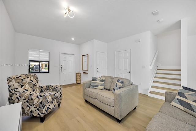 living room with stairs and light wood finished floors